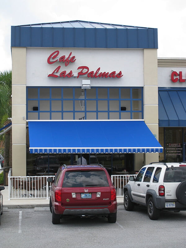 Restaurant With Blue Awning Over Outdoor Seating Area