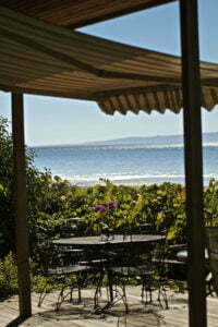 Retractable Awning Providing Sun Protection For A Patio With The Ocean In The Background 