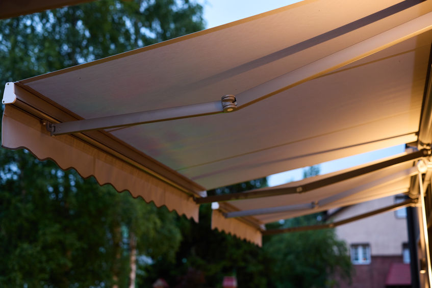 A beautifully stylish outdoor awning softly illuminated during the evening, ideal for various alfresco setups